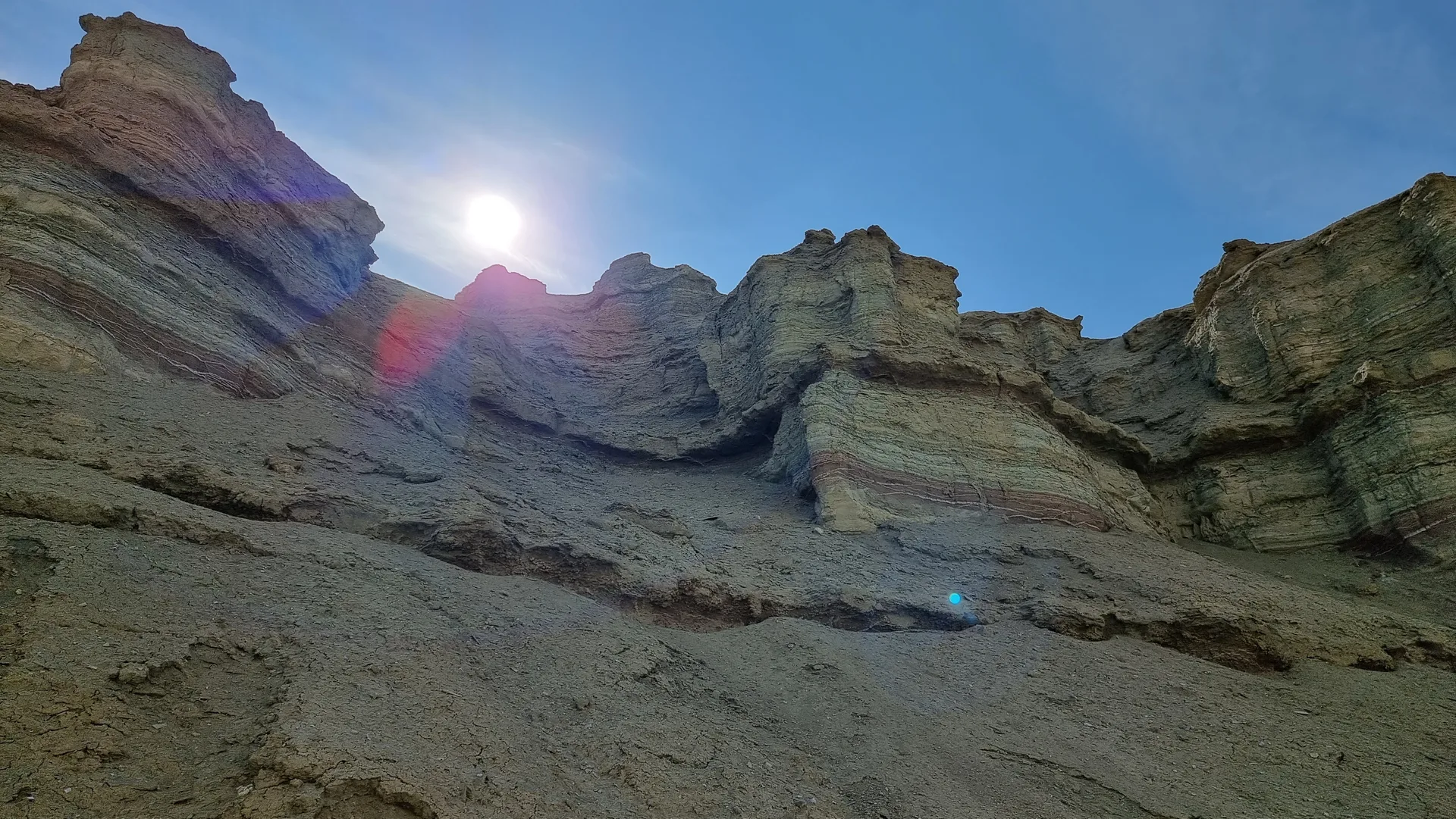 Late-afternoon view of the pale Aktau escarpment rising above flat desert scrubland, representative of the exposed camping environment near the Shygan ranger camp.