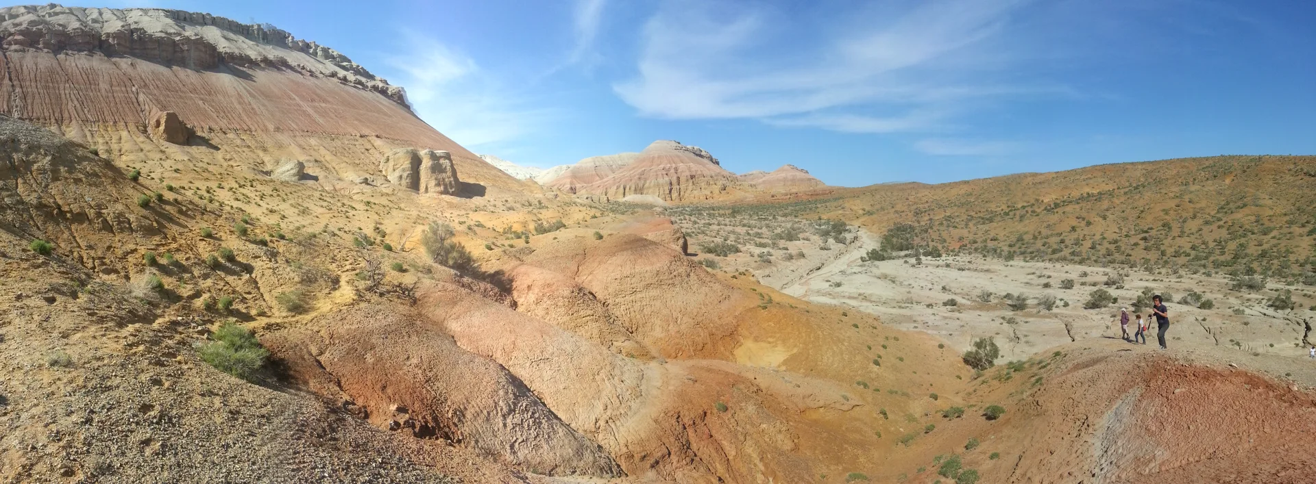 Panoramic view of the Aktau multicolored chalk mountains in Altyn-Emel National Park, Kazakhstan, showing layered red, white and yellow sedimentary bands rising from the steppe.