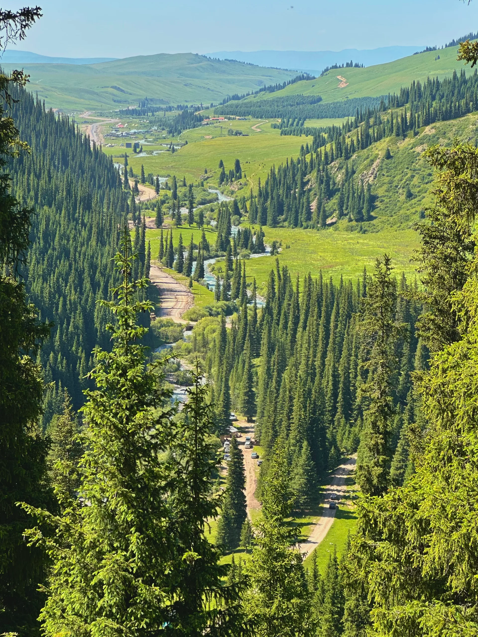 Karkara river valley seen from 2,398 m elevation near the Kazakhstan-Kyrgyzstan border, showing the broad intermountain valley floor with river meanders and mountain ridges