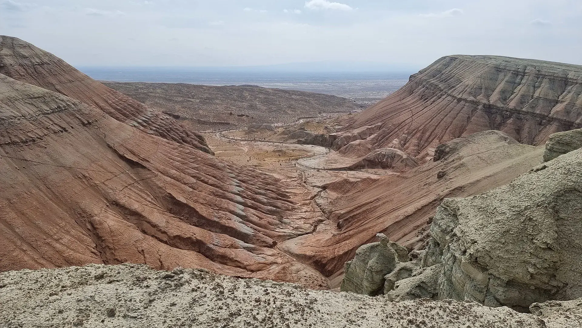 Wide approach view of the Aktau escarpment rising from the desert floor.
