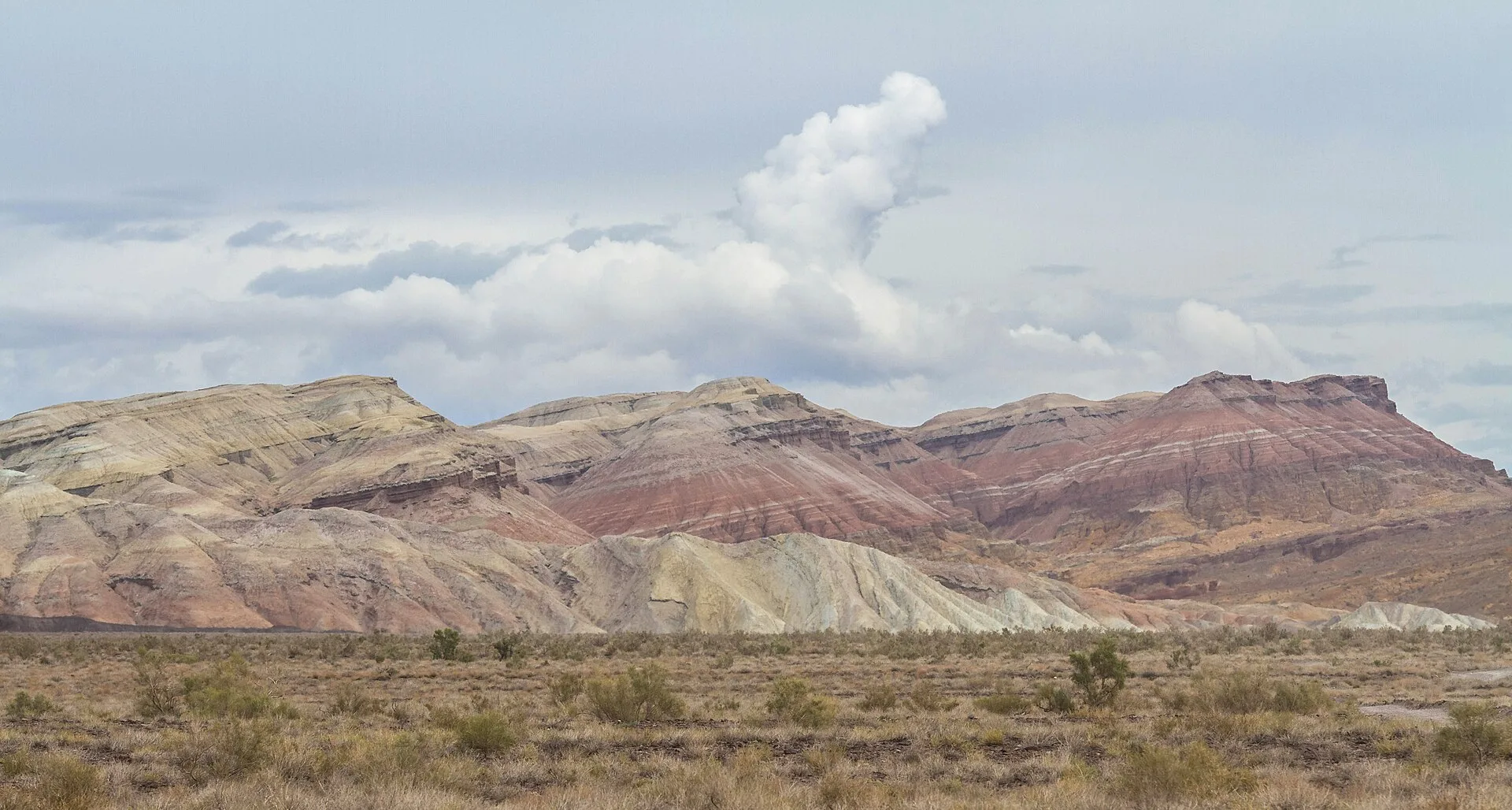 Layered chalk mountains of Aktau seen as a broad panorama across the valley.