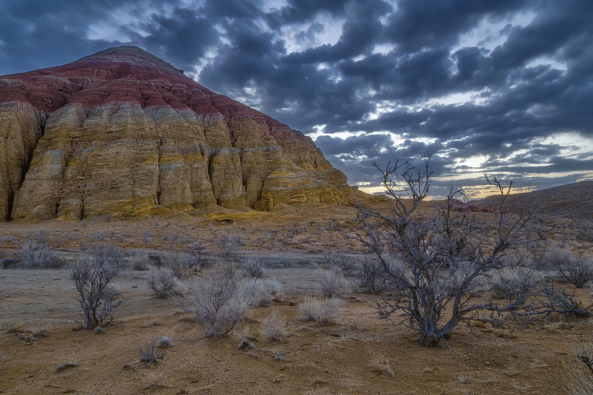 Rust-red and cream sediment layers forming a narrow Aktau gorge passage.