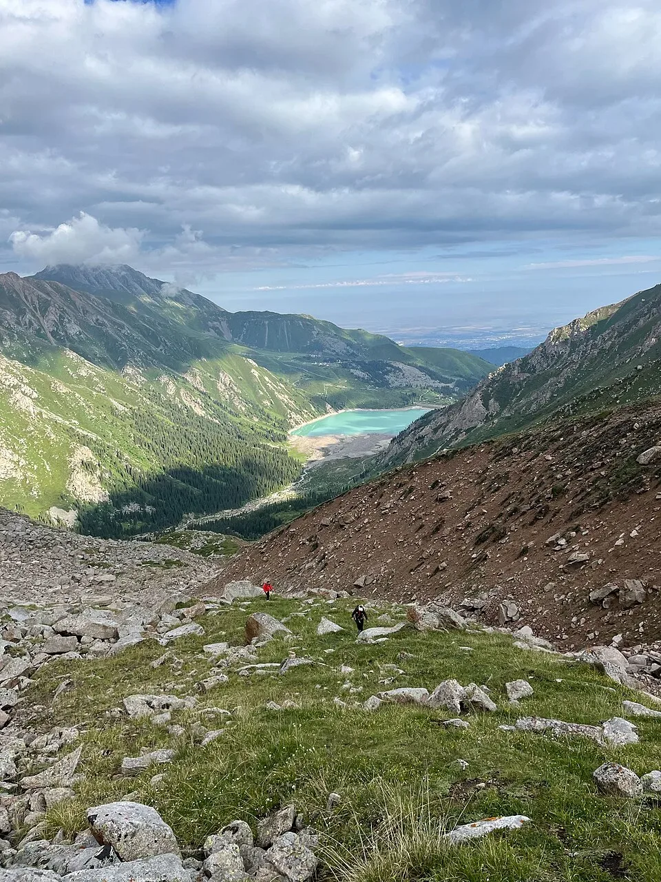 Context near Ayusay Visitor Centre Gorge Checkpoint: Big Almaty Lake seen from a mountain overlook with steep grey slopes around the water.