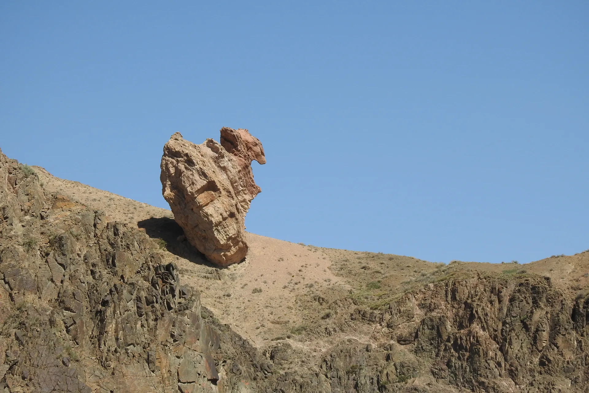 Eroded towers in the Valley of Castles rising above scrub on the canyon floor.