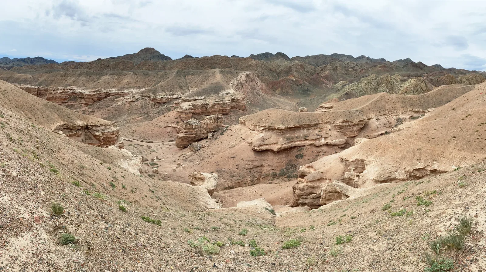 Context near Charyn Canyon Valley Of Castles: Wide canyon panorama with eroded red walls below an open blue sky.