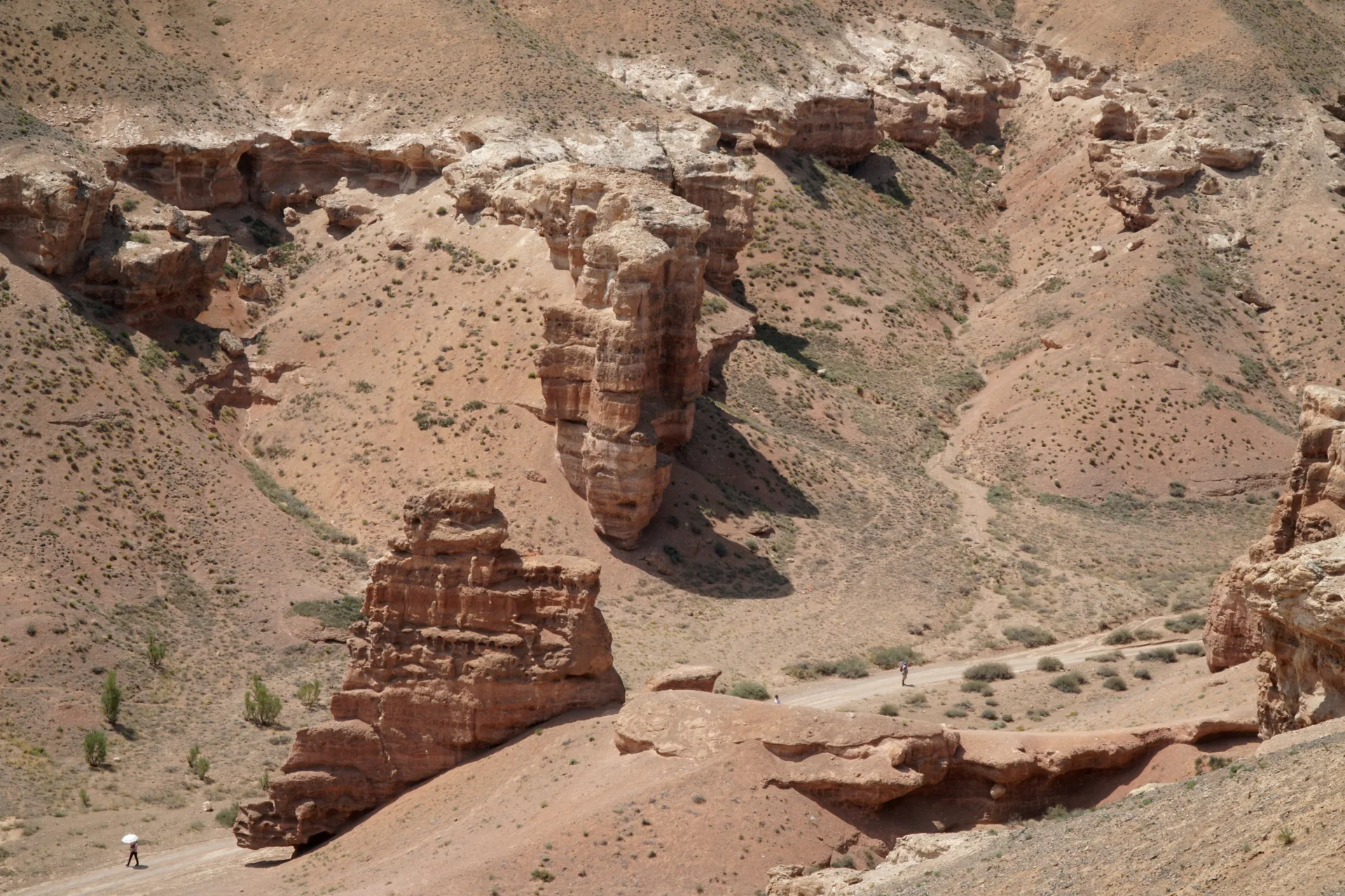 Tall sandstone forms lining a dry corridor in Charyn Canyon.