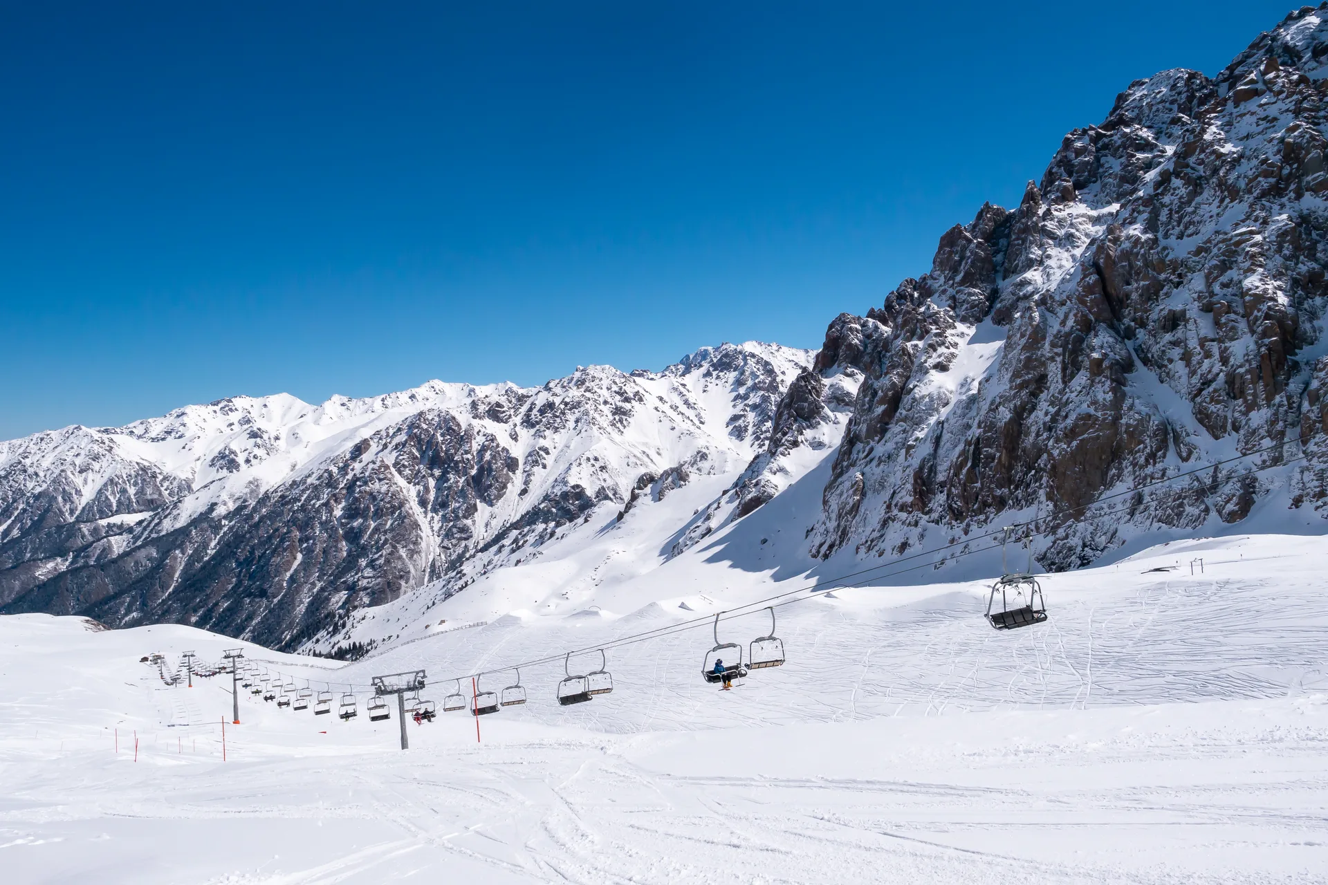 Shymbulak mountain slope infrastructure above Almaty on a clear day.
