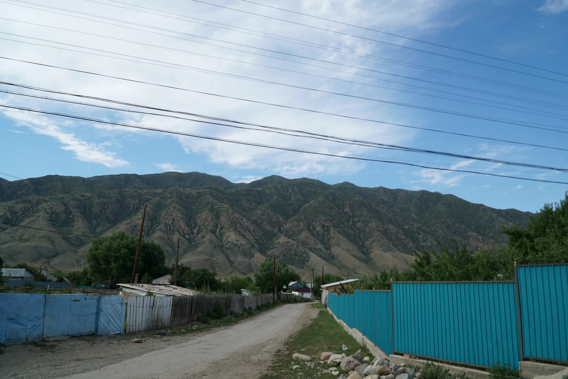 Unpaved mountain track crossing grassy terrain near Saty.