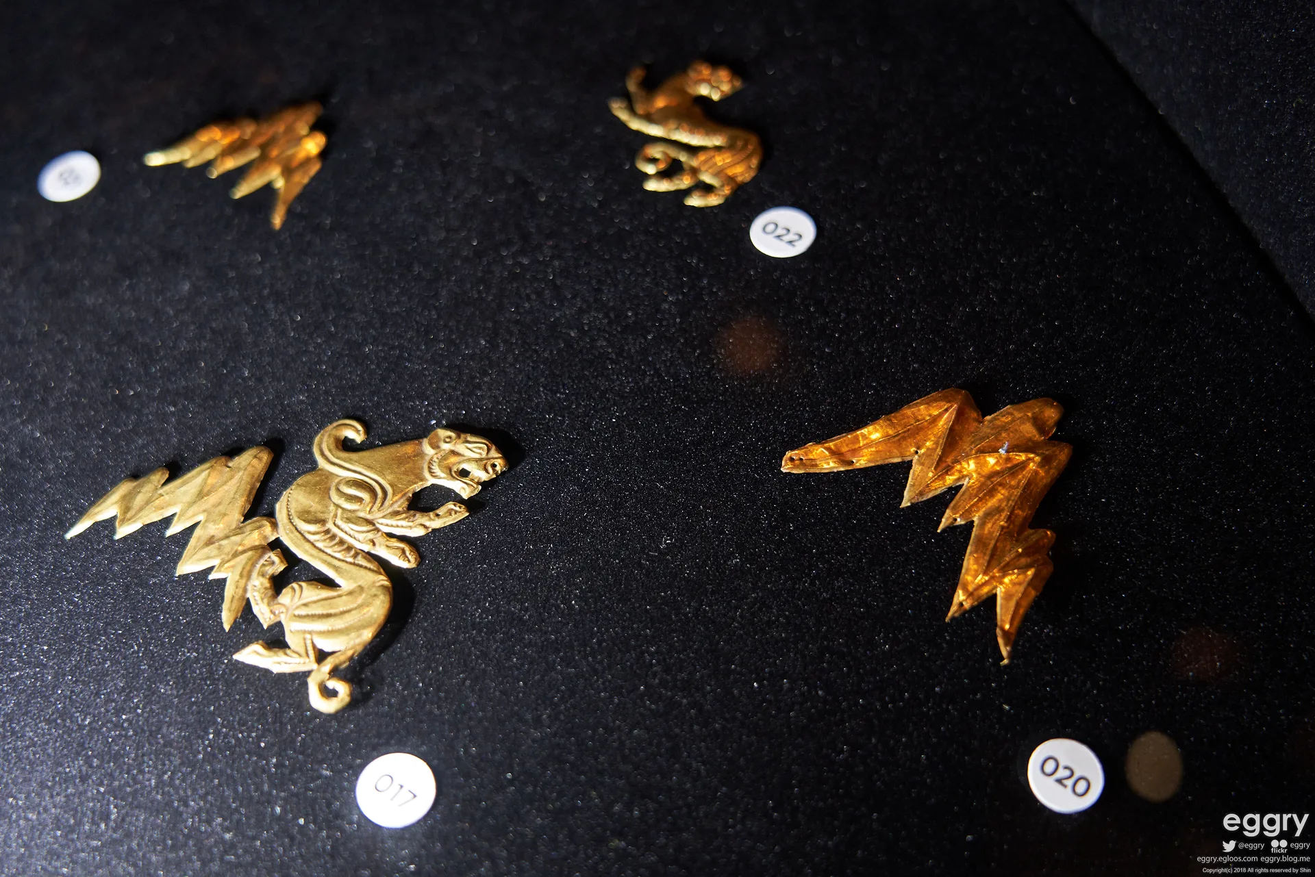 Gold objects from the Issyk kurgan arranged in a museum display case.