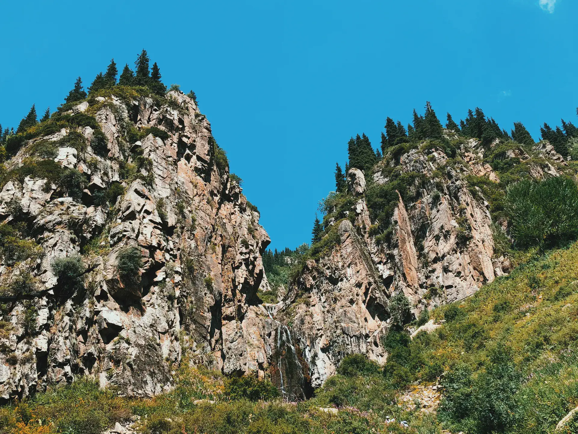 Rock wall and waterfall setting on the Butakovka route above the trailhead.