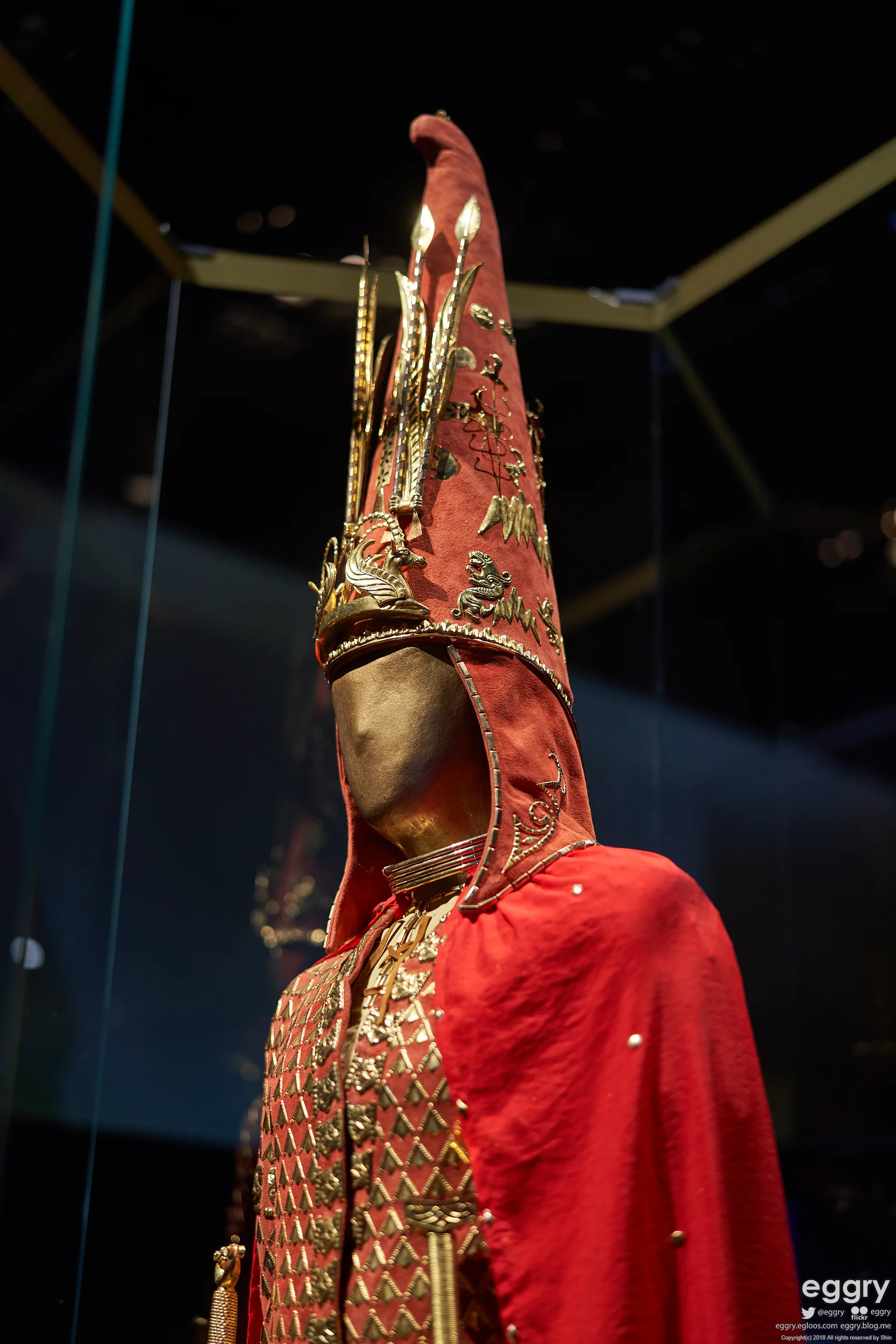 Close view of the Issyk Golden Man headgear with small gold animal ornaments and vertical decorative elements.