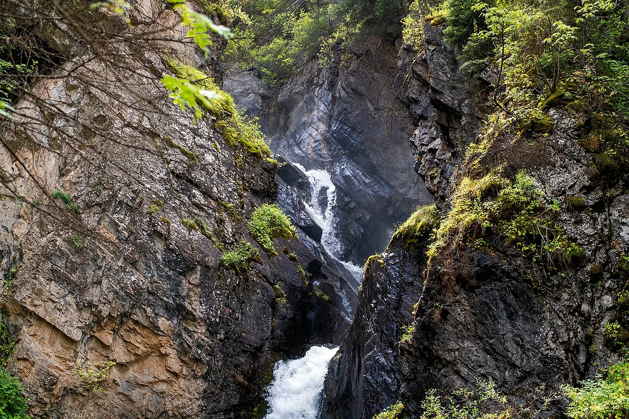Wide view of Kairak Waterfall fanning down the rock face into the shaded Turgen gorge.