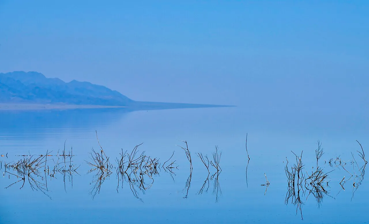 Broad calm water surface on Kapchagai reservoir, showing the open blue crossing landscape beyond the dam.