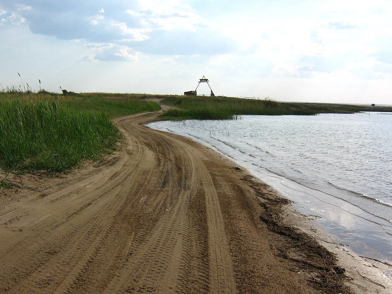 Blue Bay shoreline on Kapchagai reservoir with clear water and pale semi-desert banks.