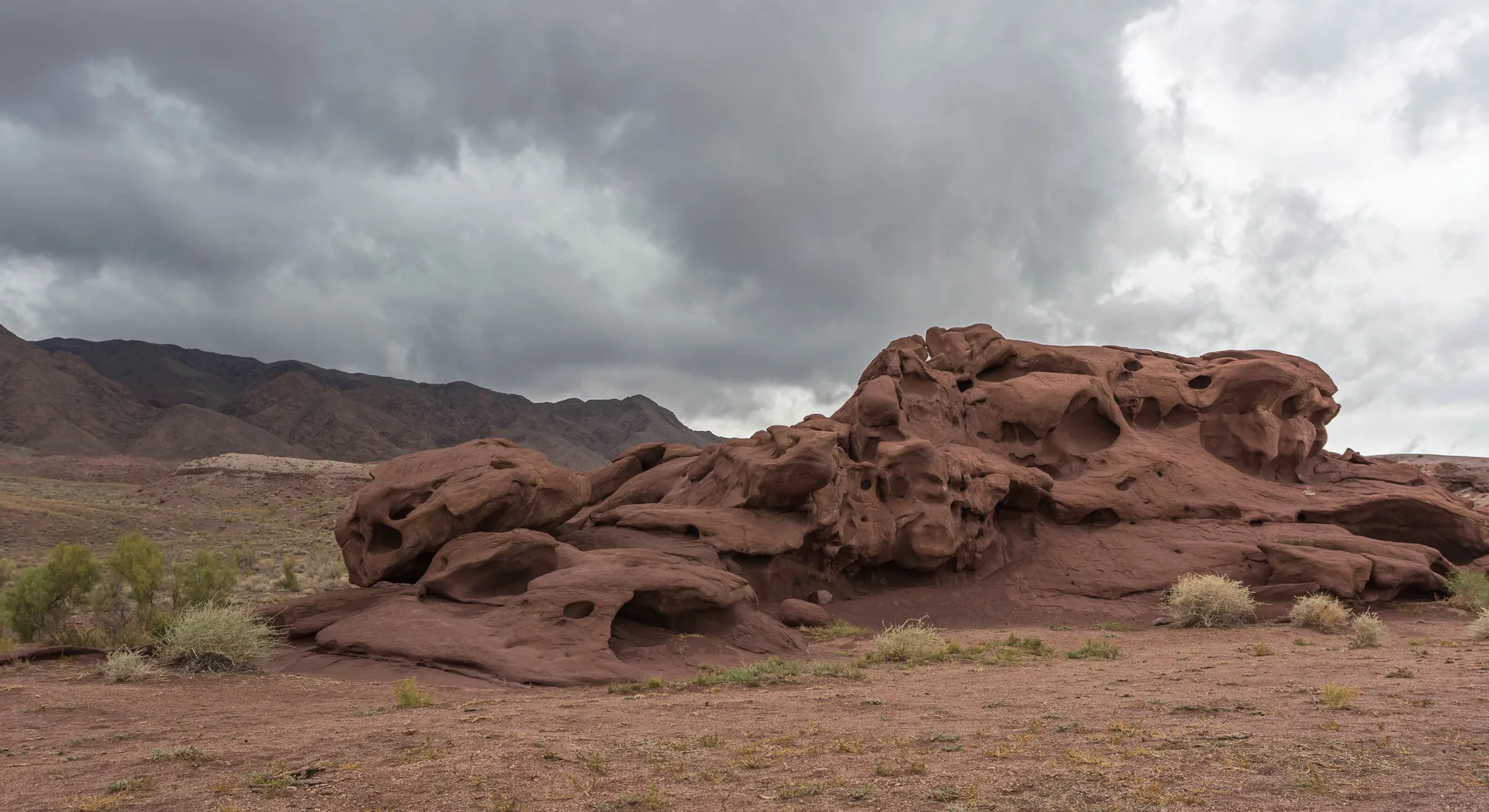 Wide view of the Katutau Mountains, with dark eroded ridges rising from pale desert scrub.