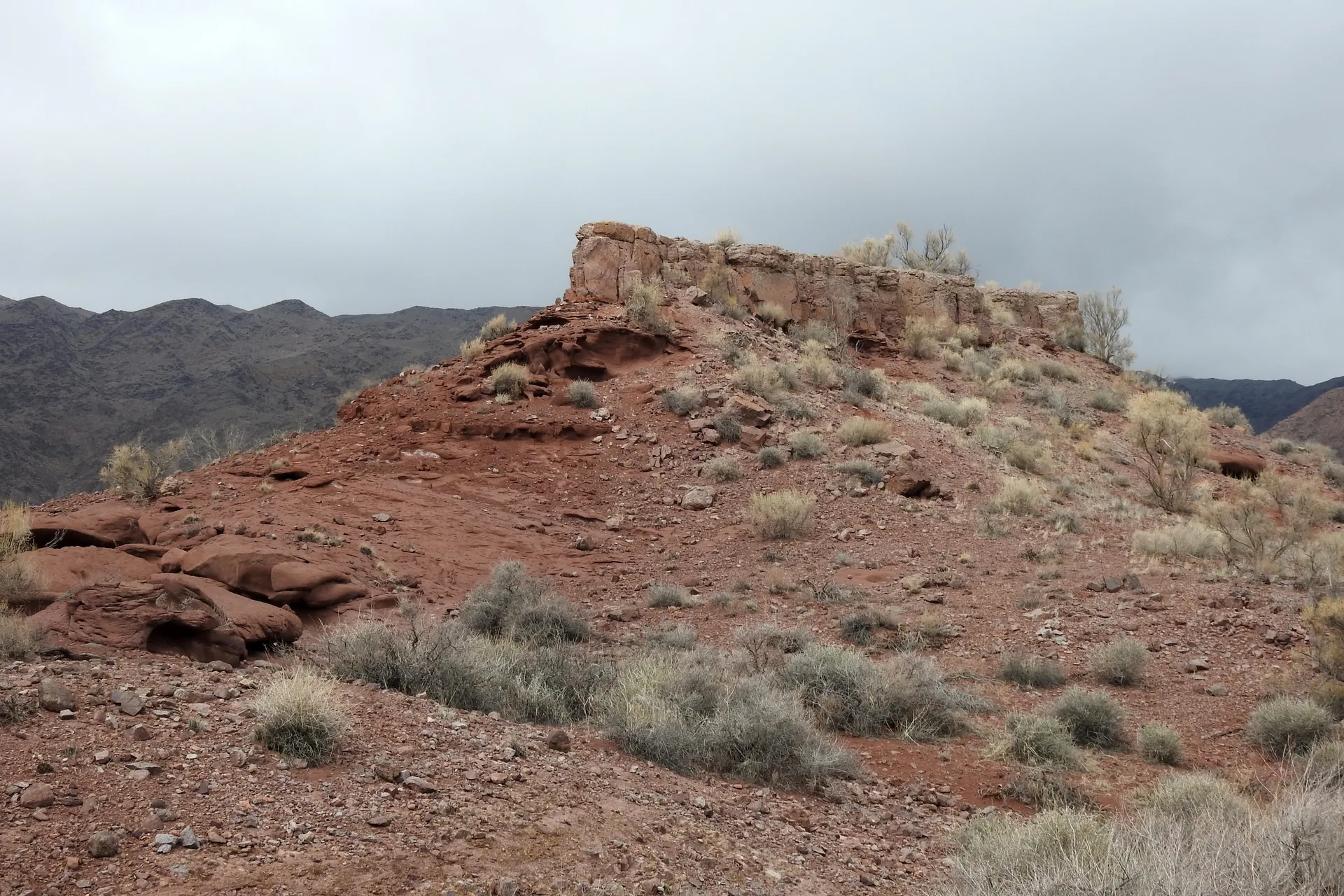 Basalt outcrops standing on a Katutau hillside, with isolated dark rock pillars above desert ground.