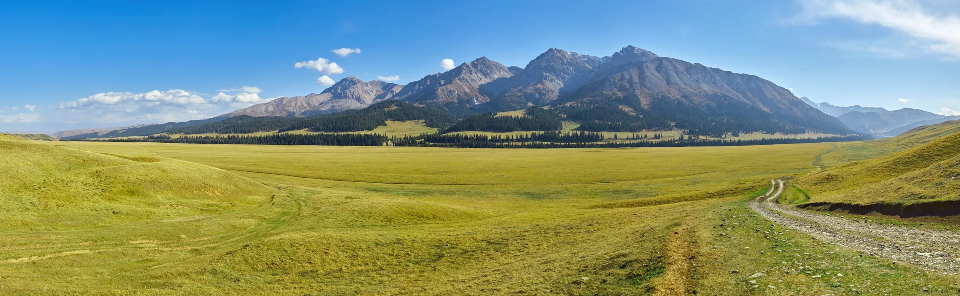Broad alpine meadow in Kegen District, showing high pasture terrain typical of the surrounding supply routes.
