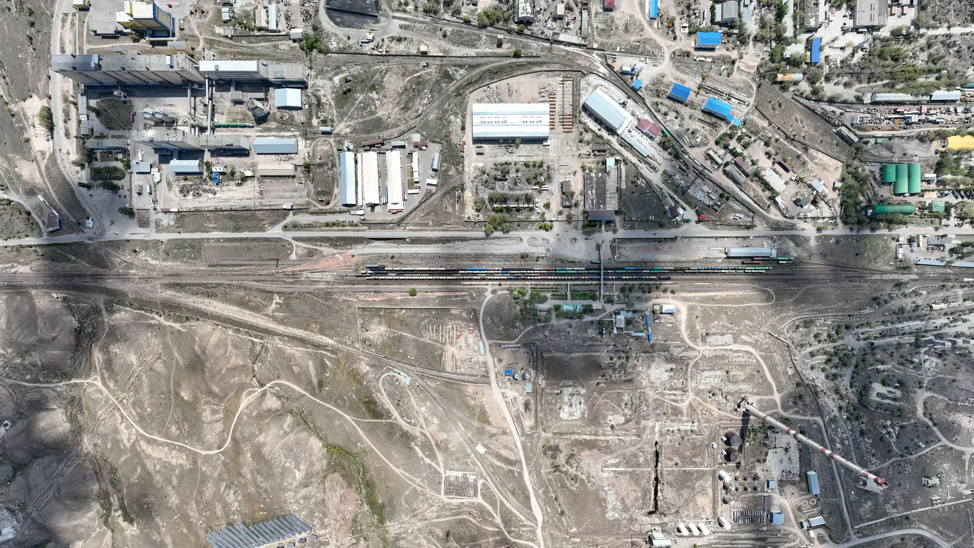 Aerial view of Kapchagai railway station in Konaev, with tracks and town streets near the fuel stop corridor.