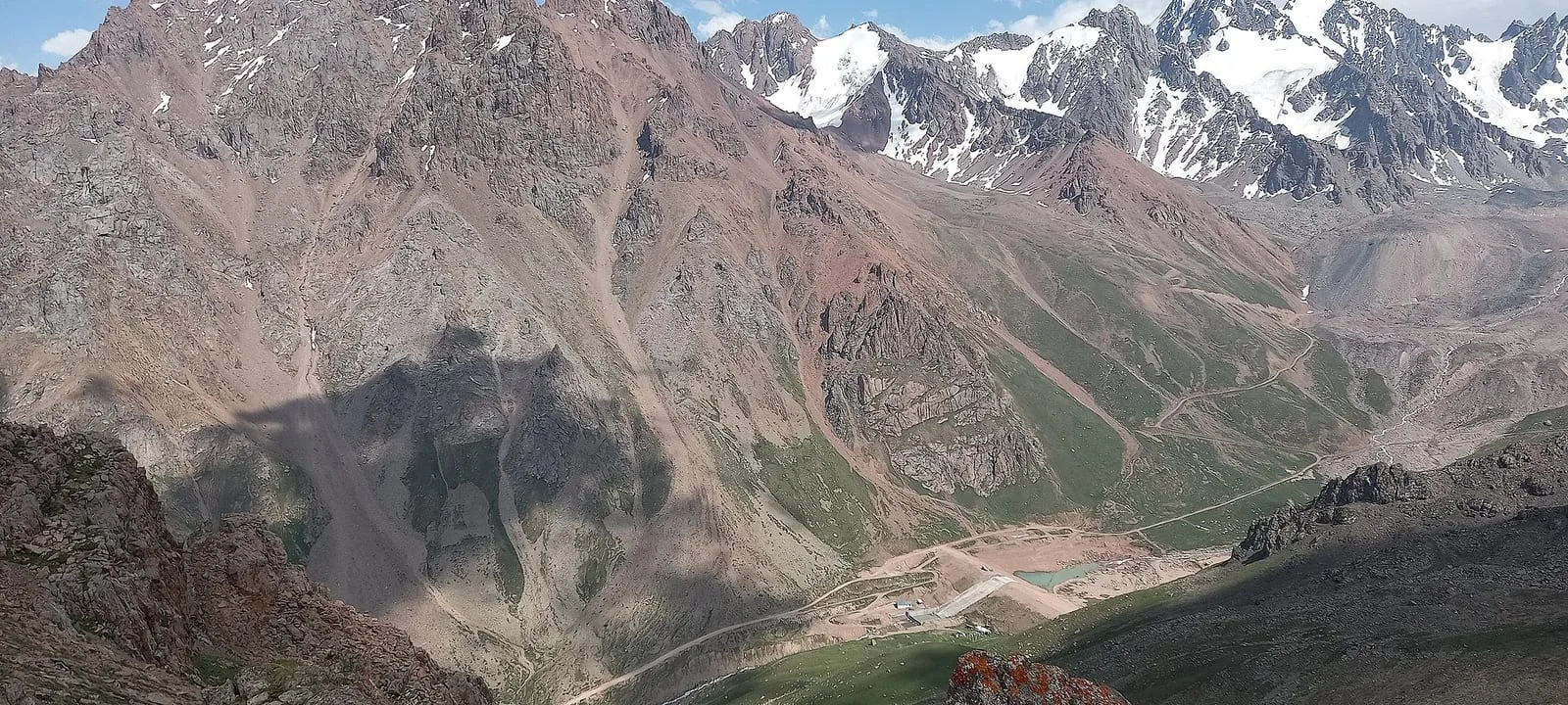 Context near Ordzhonikidze Cirque Lateral Moraine Ridge: Mynzhylky dam and high mountain basin seen from the Tuyuk-Su Gate ridge.
