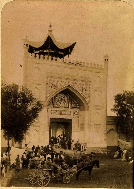 Black-and-white photograph from 1890–1900 showing the ornate carved wooden gateway of the Taranchi Mosque in Jarkent, with decorative pointed arch framing