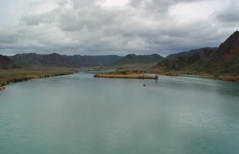 Wide Ile River channel with sandy banks and sparse riparian vegetation near the Panfilov district route.