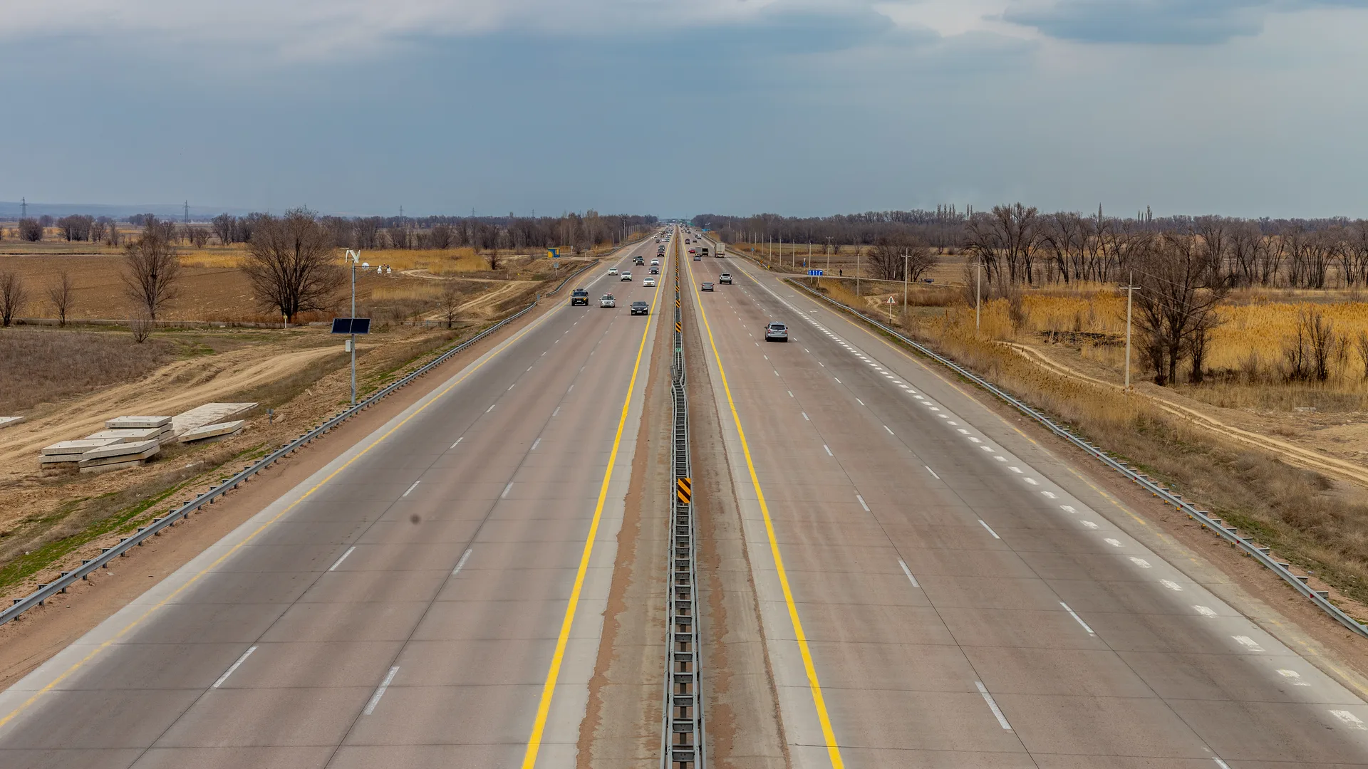A second view of the A-3 highway corridor near Almaty, with divided carriageways crossing the flat Ili-side plain.