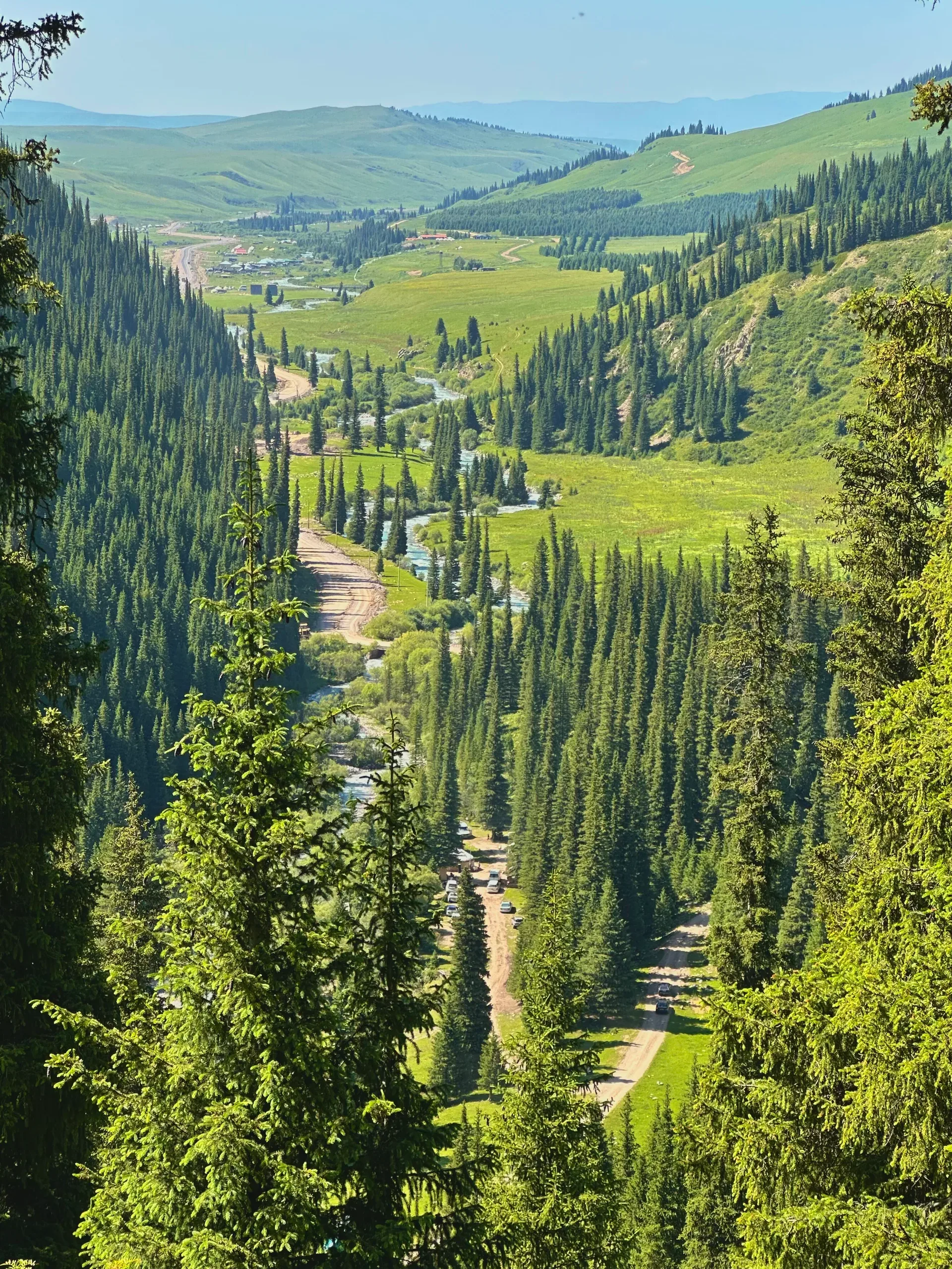 Karkara river valley seen from 2,398 m elevation near the Kazakhstan-Kyrgyzstan border, showing the broad intermountain valley floor with river meanders and mountain ridges