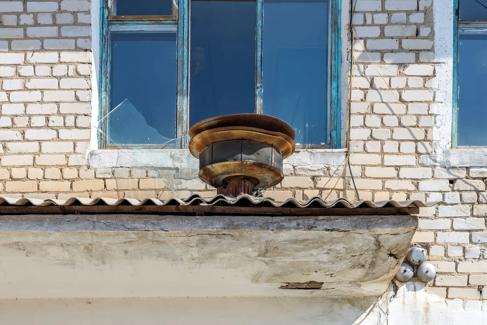 Context near Ushtobe Bazaar Koryo Saram Material Culture: Quiet Bastobe street corner near Ushtobe with low houses and a pole-mounted siren.