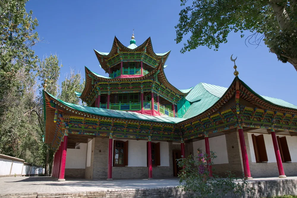 Courtyard exterior at Zharkent Mosque with timber galleries and painted architectural details.