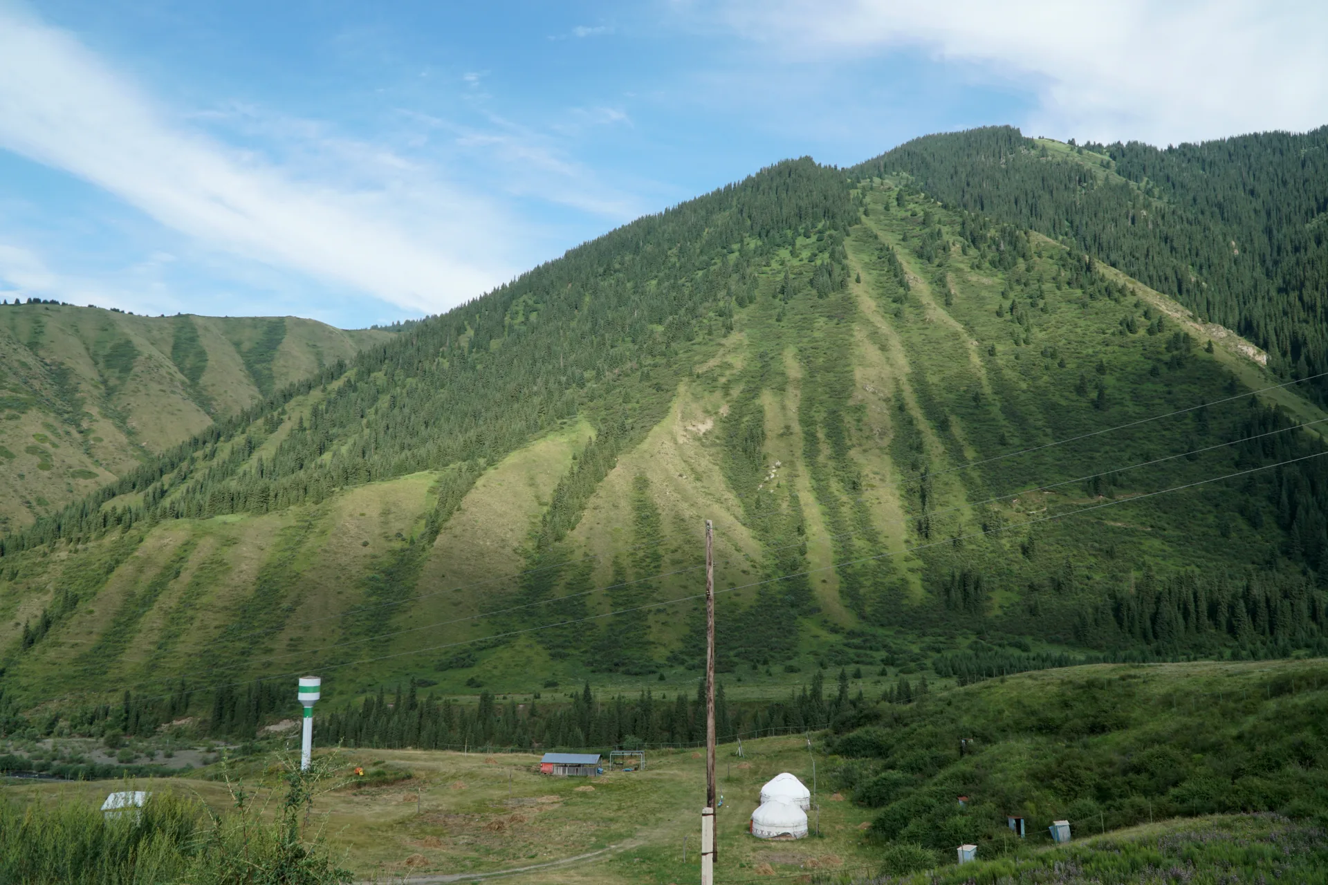High mountain ridgeline and alpine terrain in the Saty area, Almaty Region, Kazakhstan, with rocky slopes and open sky visible in summer.