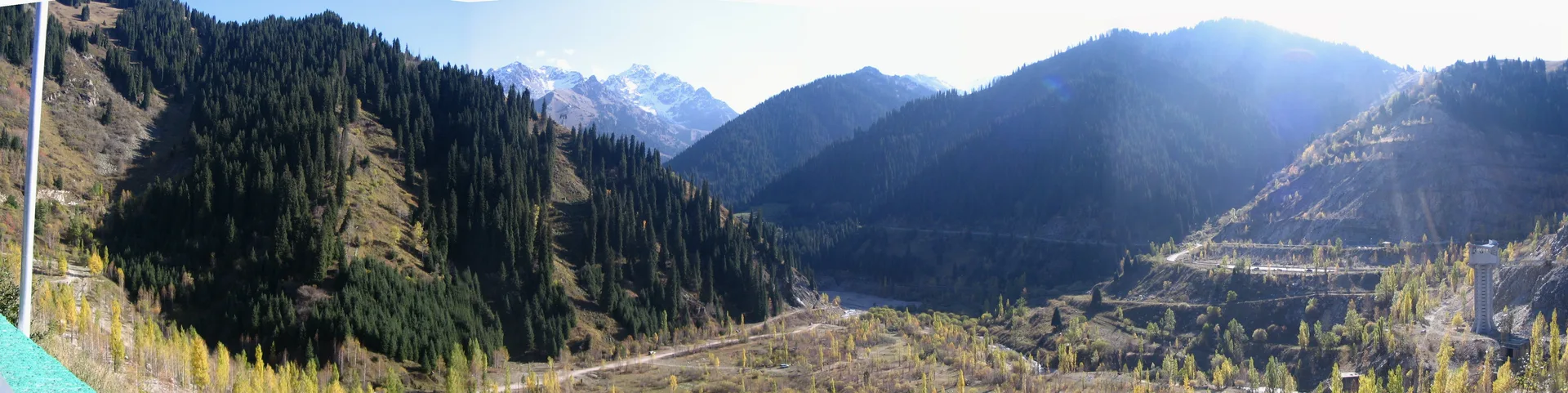 Medeu anti-mudflow dam viewed from the valley floor, wide concrete structure spanning the gorge above the ice rink complex