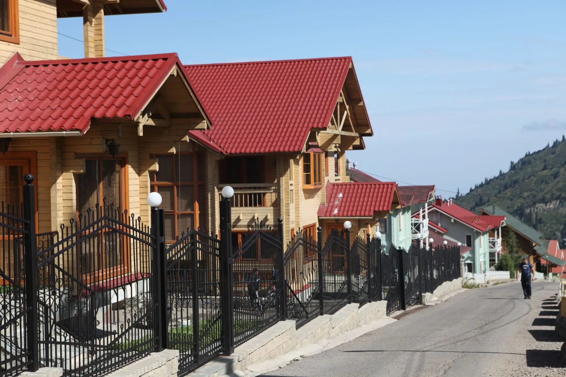Almaty street scene with tree-lined boulevard and multi-storey apartment buildings visible in morning light